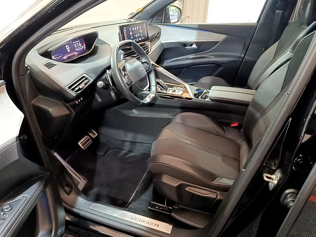 Intérieur noir du Peugeot 3008 GT 2023, vue côté conducteur, volant cuir et tableau de bord numérique lumineux.