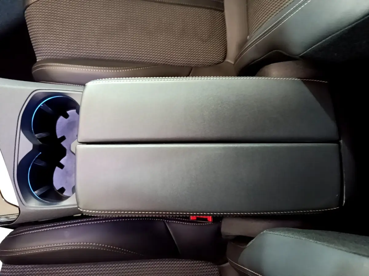 Vue plongeante sur l'accoudoir central noir et les sièges marron du Peugeot 3008 GT 2023 intérieur cuir et tissu