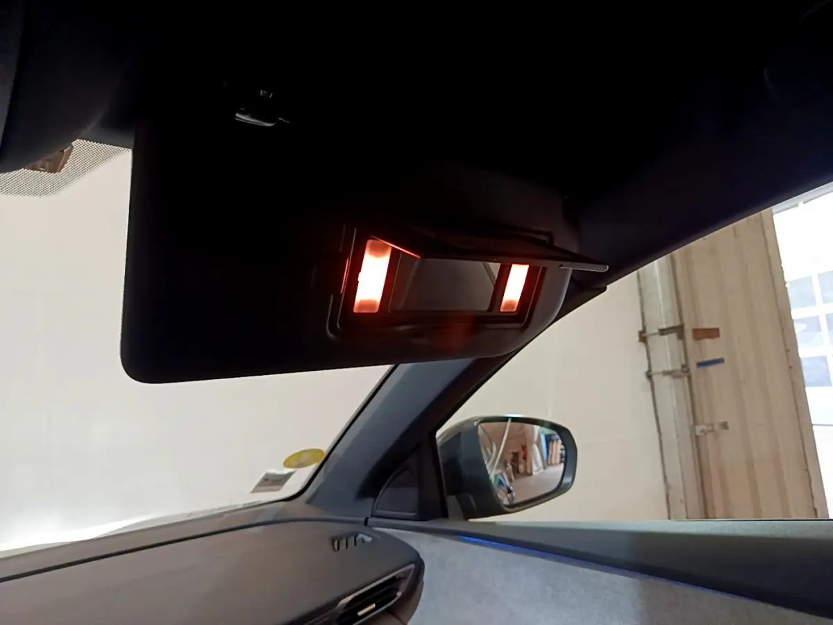 Miroir de courtoisie éclairé sur pare-soleil côté conducteur dans l'habitacle du Peugeot 3008 noir 2023.