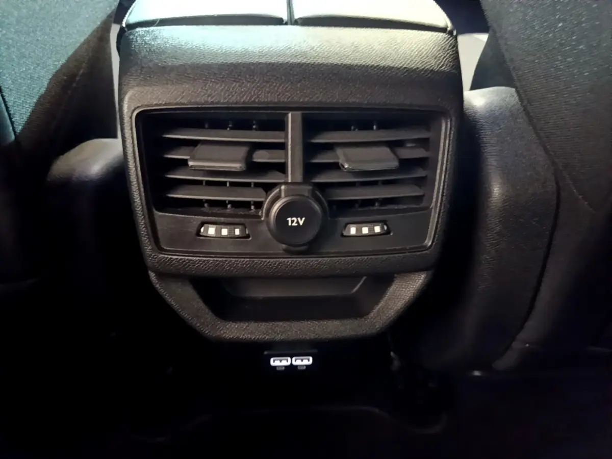 Vue rapprochée des aérateurs arrière noirs avec prise 12V et ports USB du Peugeot 3008 GT 2023.