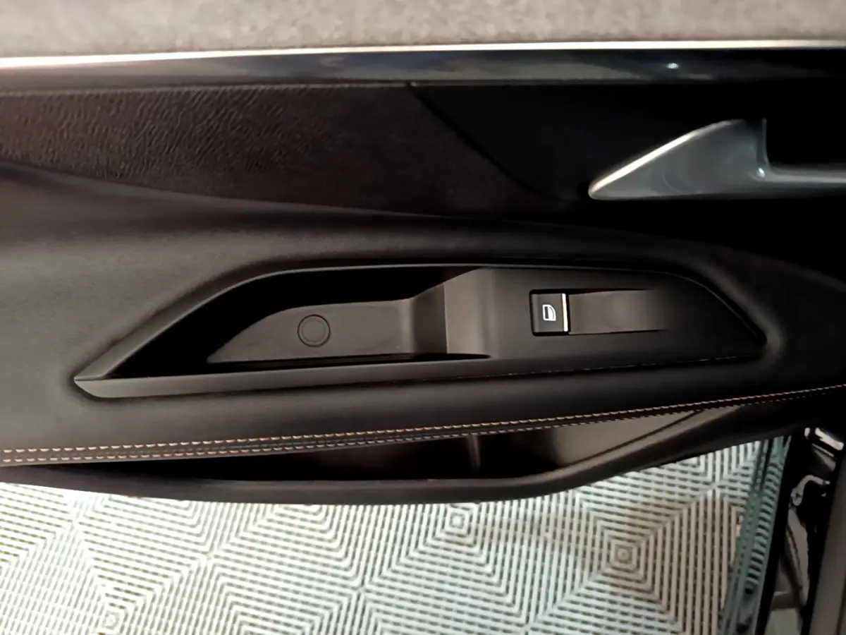Poignée intérieure côté gauche de la porte noire du Peugeot 3008 GT 2023 avec bouton de verrouillage intégré.
