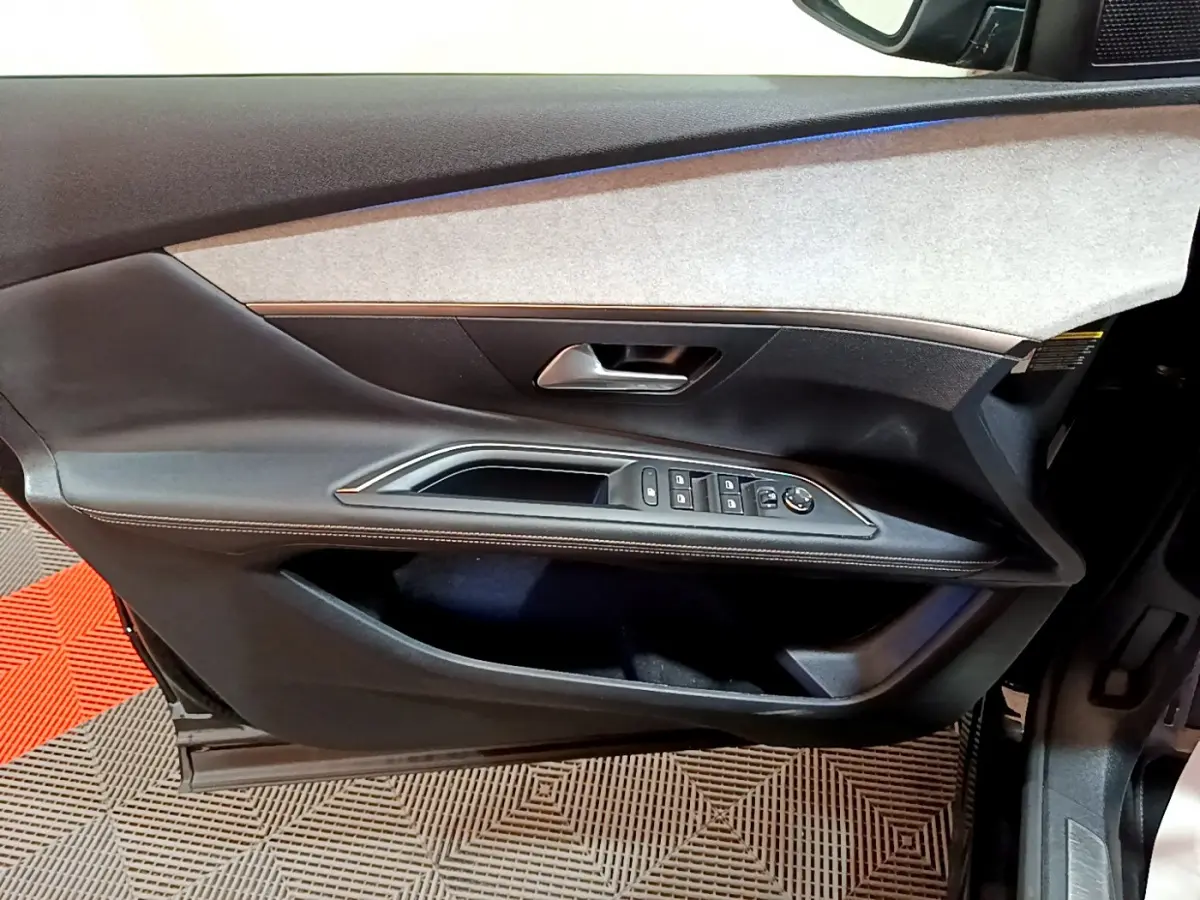 Vue rapprochée de la porte avant gauche noire du Peugeot 3008 2023, avec commandes électriques et poignée argentée.