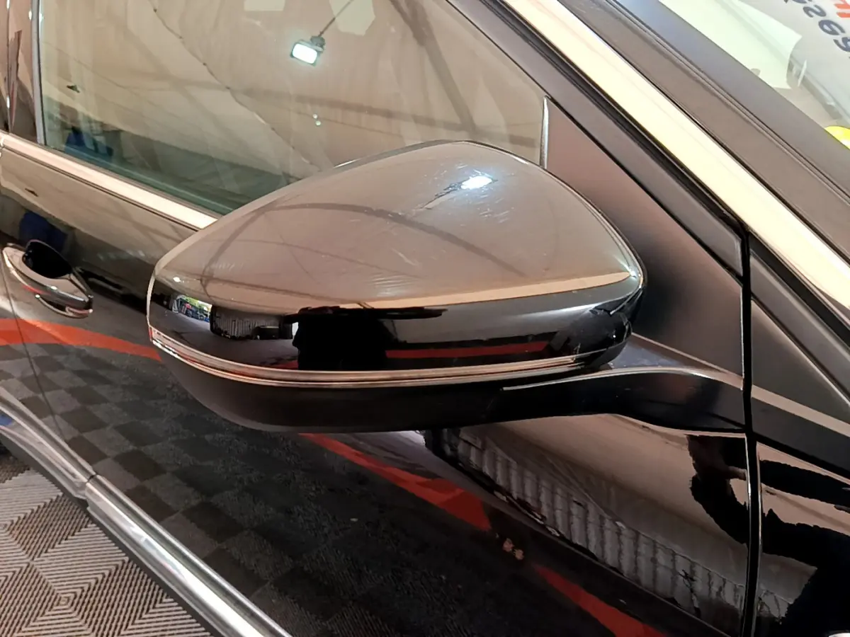 Gros plan sur le rétroviseur côté gauche noir brillant du Peugeot 3008 GT 2023 avec insert chromé.