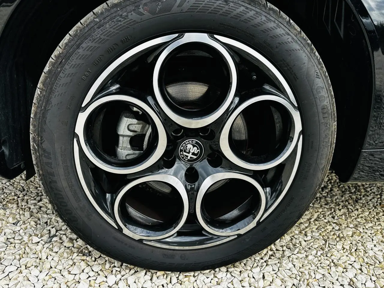 Gros plan sur la roue arrière droite d'une Alfa Romeo Tonale bleu métallisé, avec pneu Goodyear visible.