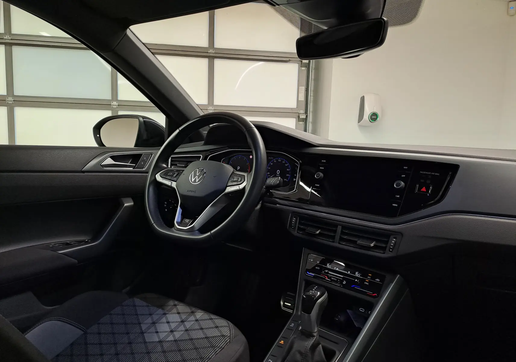 Vue intérieure côté conducteur du Volkswagen Taigo 2025 noir intense, volant multifonction et tableau de bord digital.