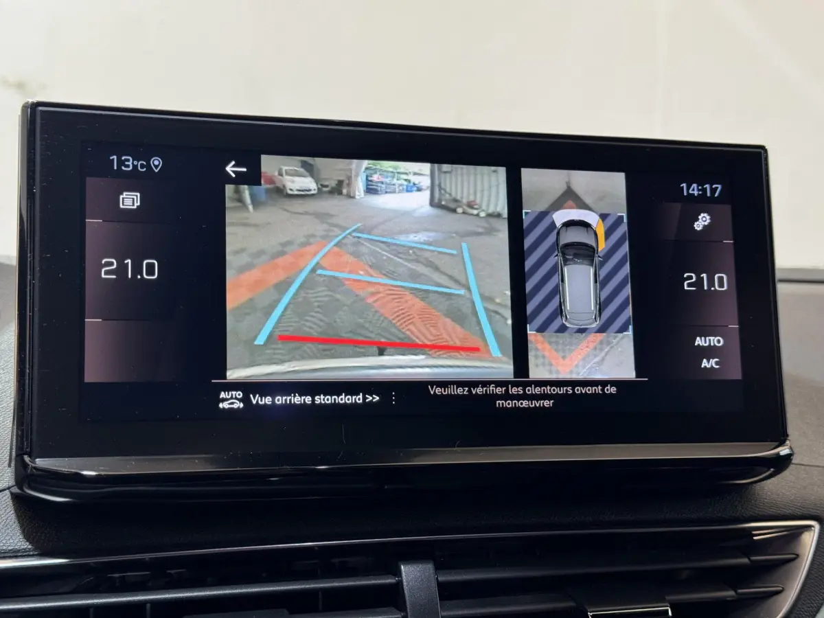 Écran tactile du tableau de bord du Peugeot 3008 gris clair montrant la caméra de recul et l'aide au stationnement arrière.
