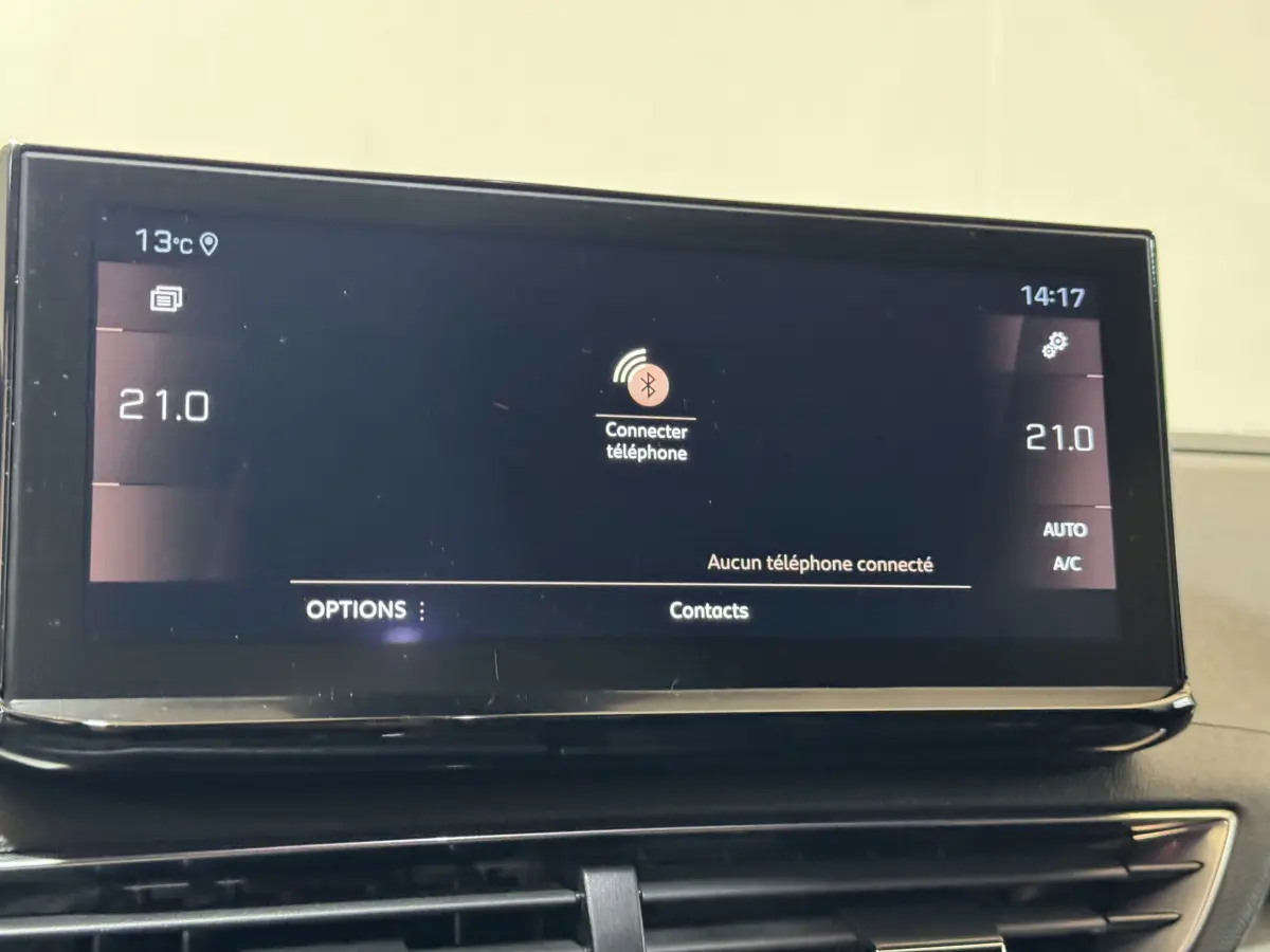 Écran tactile central du tableau de bord du Peugeot 3008 gris clair affichant la connexion Bluetooth et la température à 21°C.