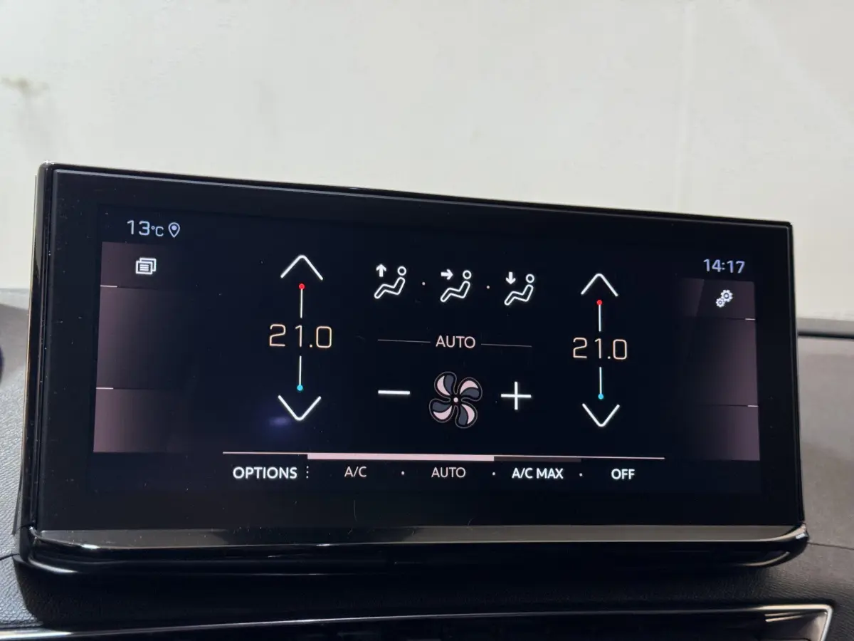 Écran tactile central affichant la climatisation à 21°C dans le Peugeot 3008 GT gris clair, vue intérieure rapprochée.