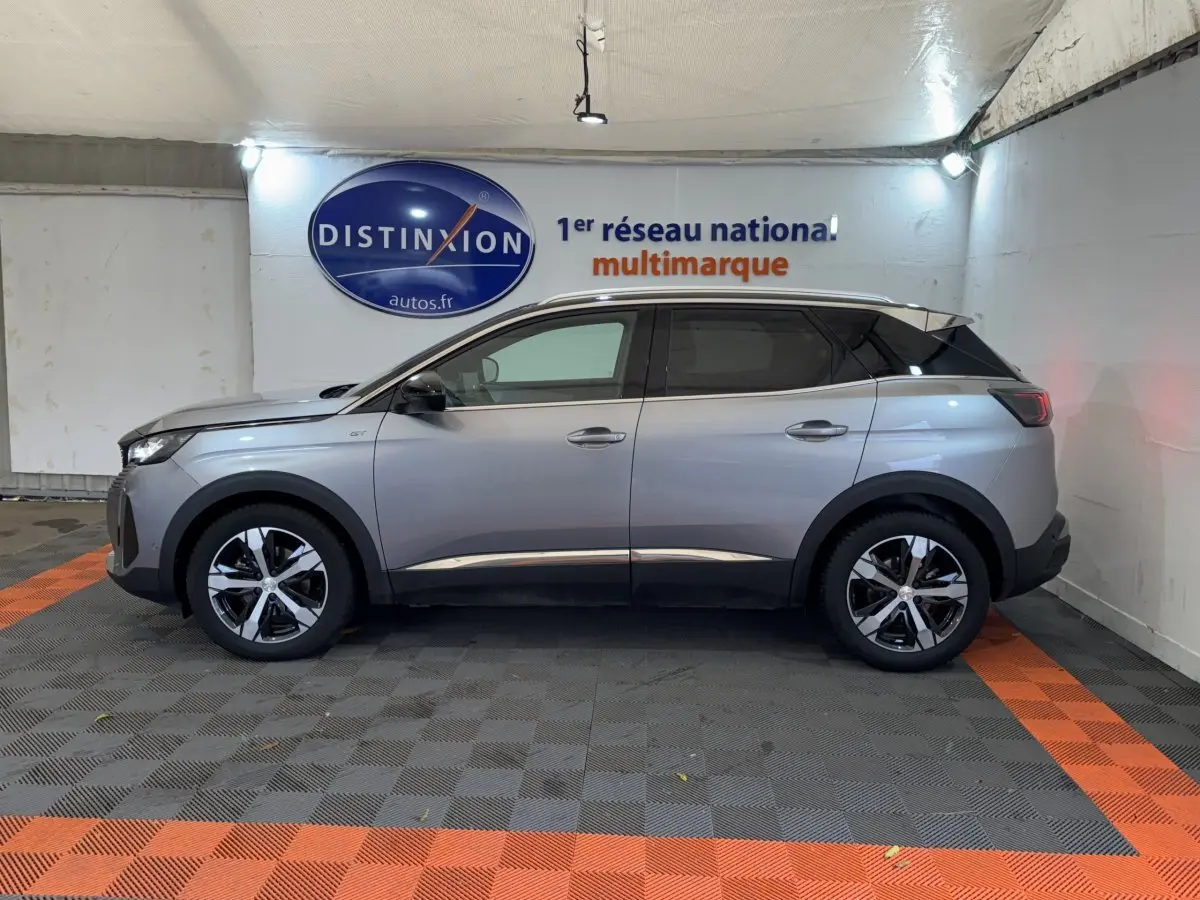 Peugeot 3008 BlueHDi 130 GT gris clair vue de profil côté gauche dans un showroom avec logo Distinxion.