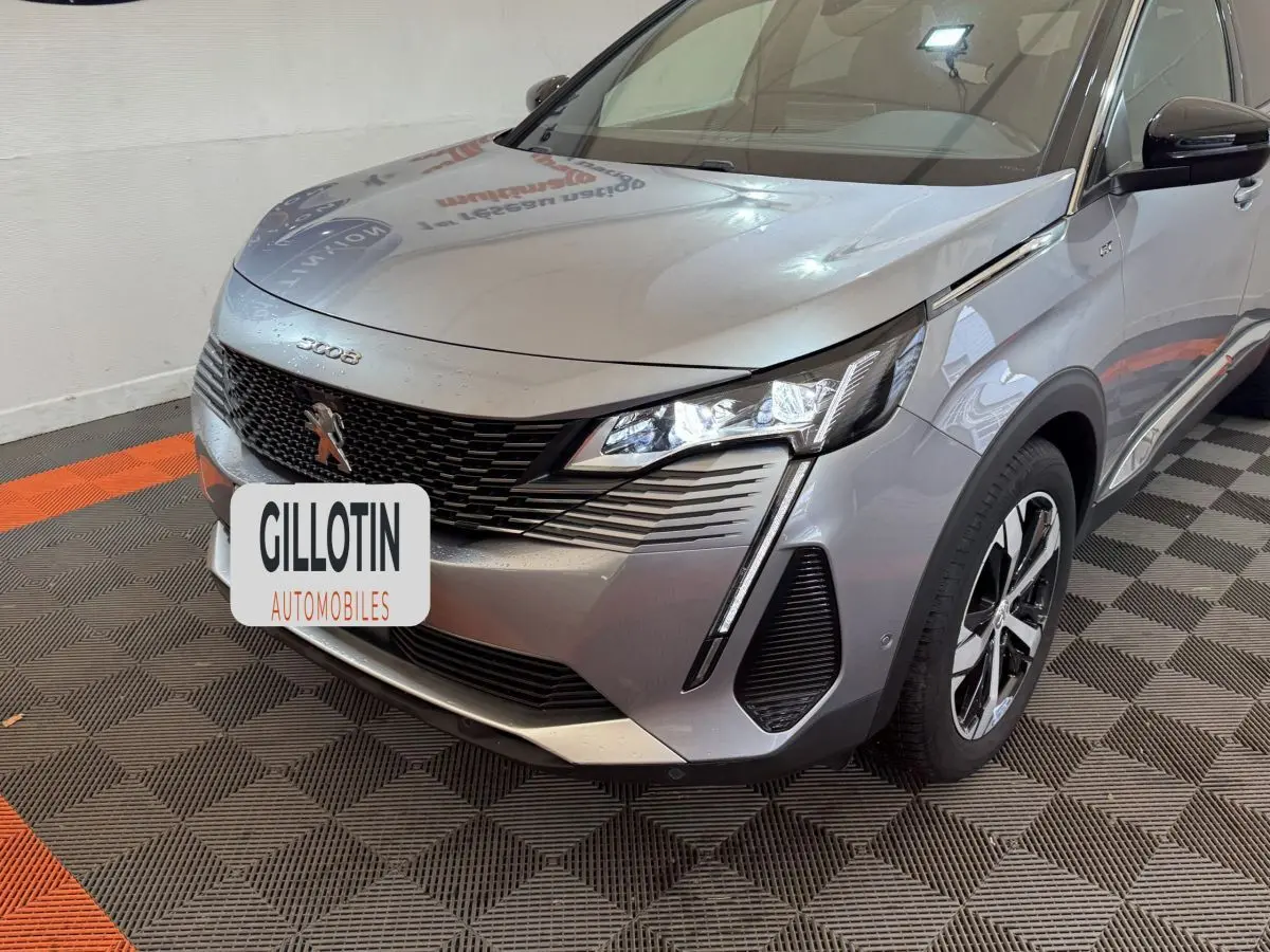 Vue 3/4 avant droit d’un Peugeot 3008 gris clair avec calandre noire et feux LED distinctifs.
