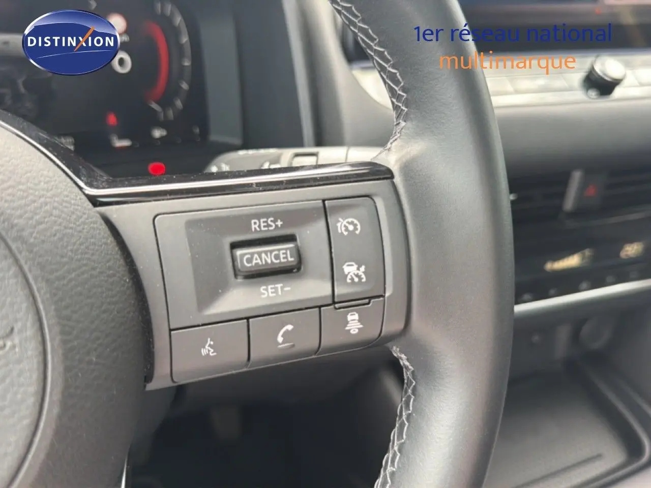 Gros plan sur les commandes au volant du Nissan Qashqai e-POWER 2023, finition Business Edition, intérieur cuir noir.
