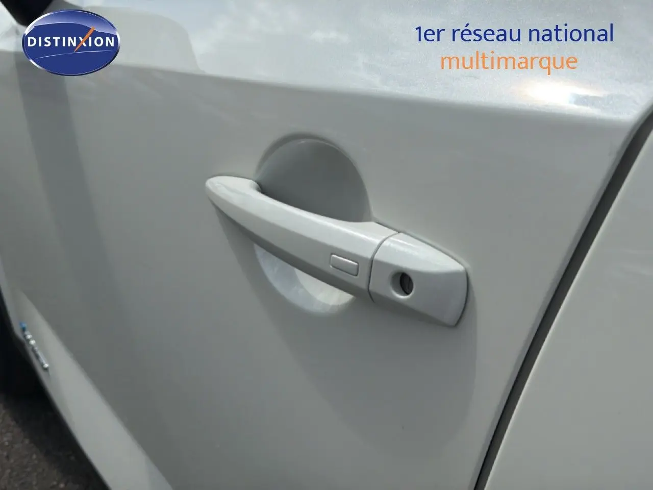 Poignée de porte côté gauche du Nissan Qashqai blanc nacré métal, vue rapprochée sur la serrure et la poignée.