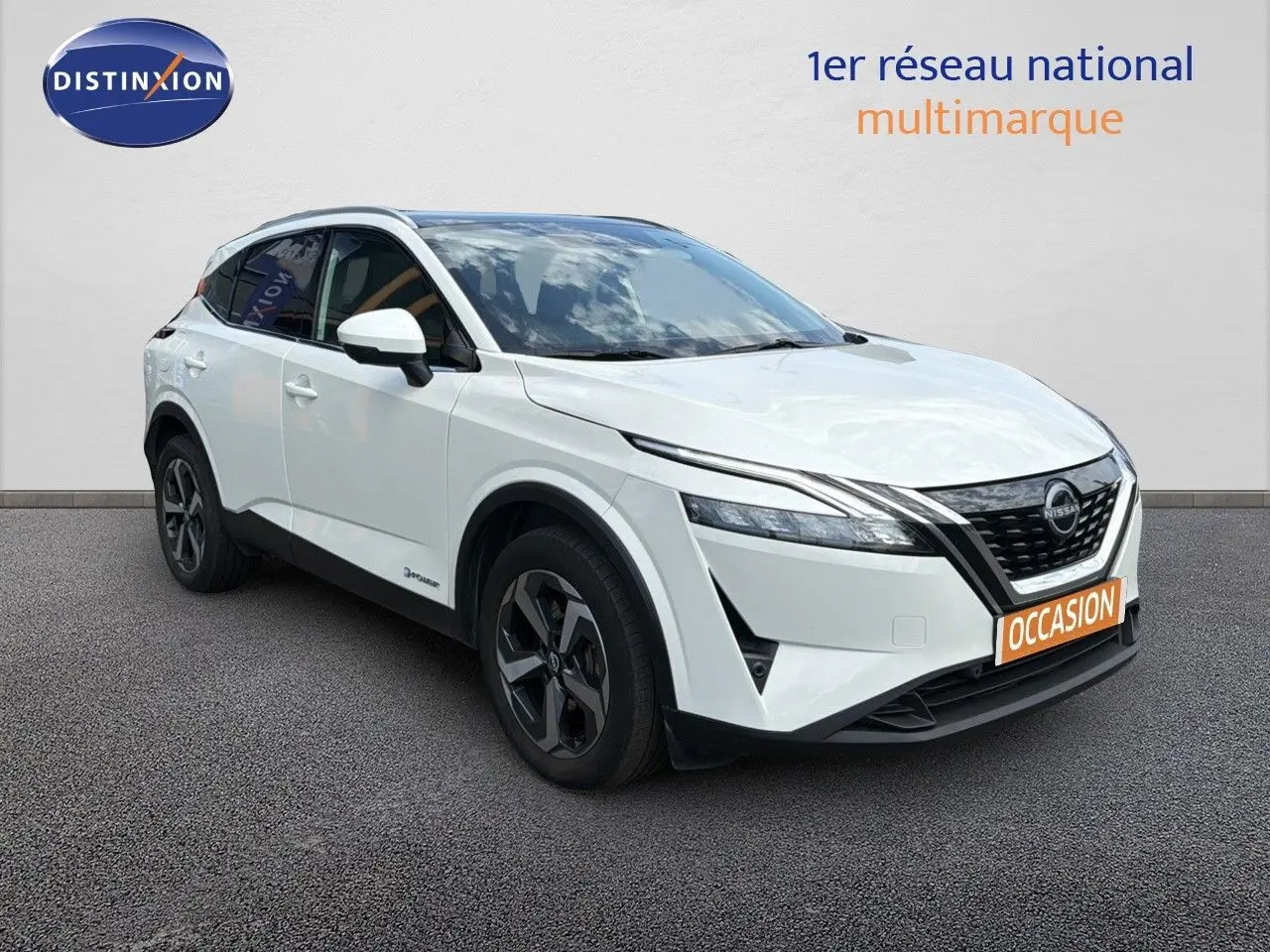 Nissan Qashqai e-POWER blanc nacré métal en 3/4 avant droit avec jantes noires et calandre marquée.