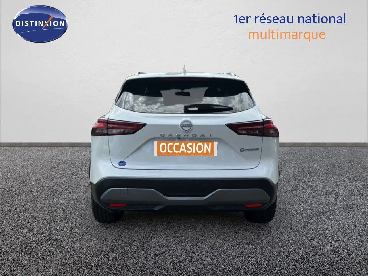 Vue arrière d'un Nissan Qashqai e-POWER blanc nacré métal avec logo et feux arrière distinctifs, sur sol gris.