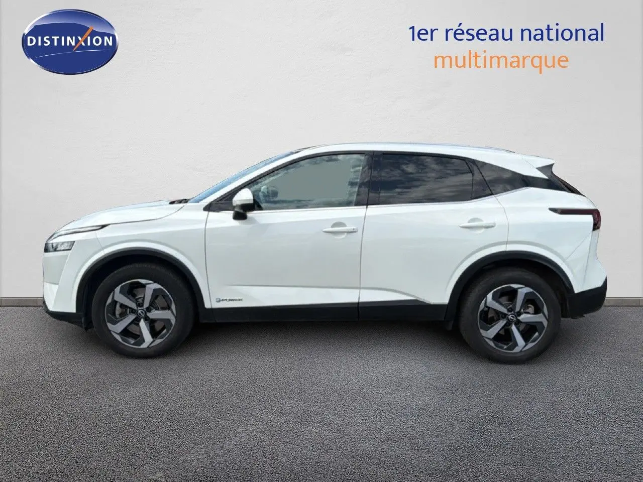 Vue de profil côté gauche d'un Nissan Qashqai e-POWER blanc nacré métallisé avec jantes bi-ton et vitres teintées.