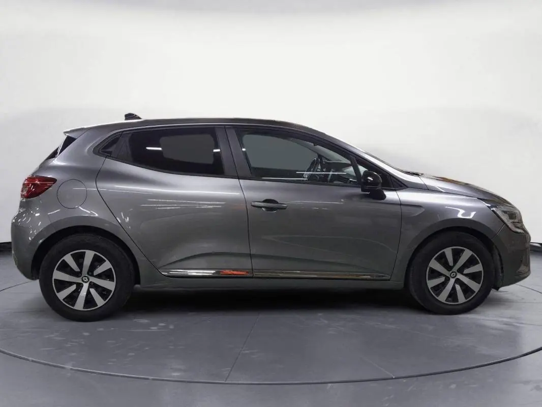 Profil côté gauche d'une Renault Clio V TCe 90 Evolution gris clair de 2023 avec jantes alliage et vitres teintées.
