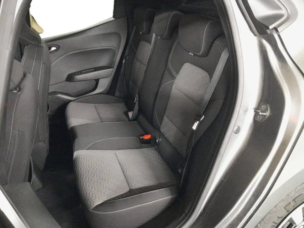 Vue intérieure côté droit sur les sièges arrière gris foncé avec surpiqûres blanches d'une Renault Clio 2023 gris clair.