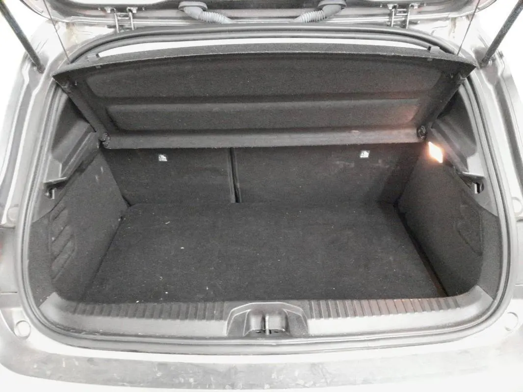 Coffre ouvert de la Renault Clio V TCe 90 Evolution gris clair 2023, vue arrière montrant l’espace de chargement vide.
