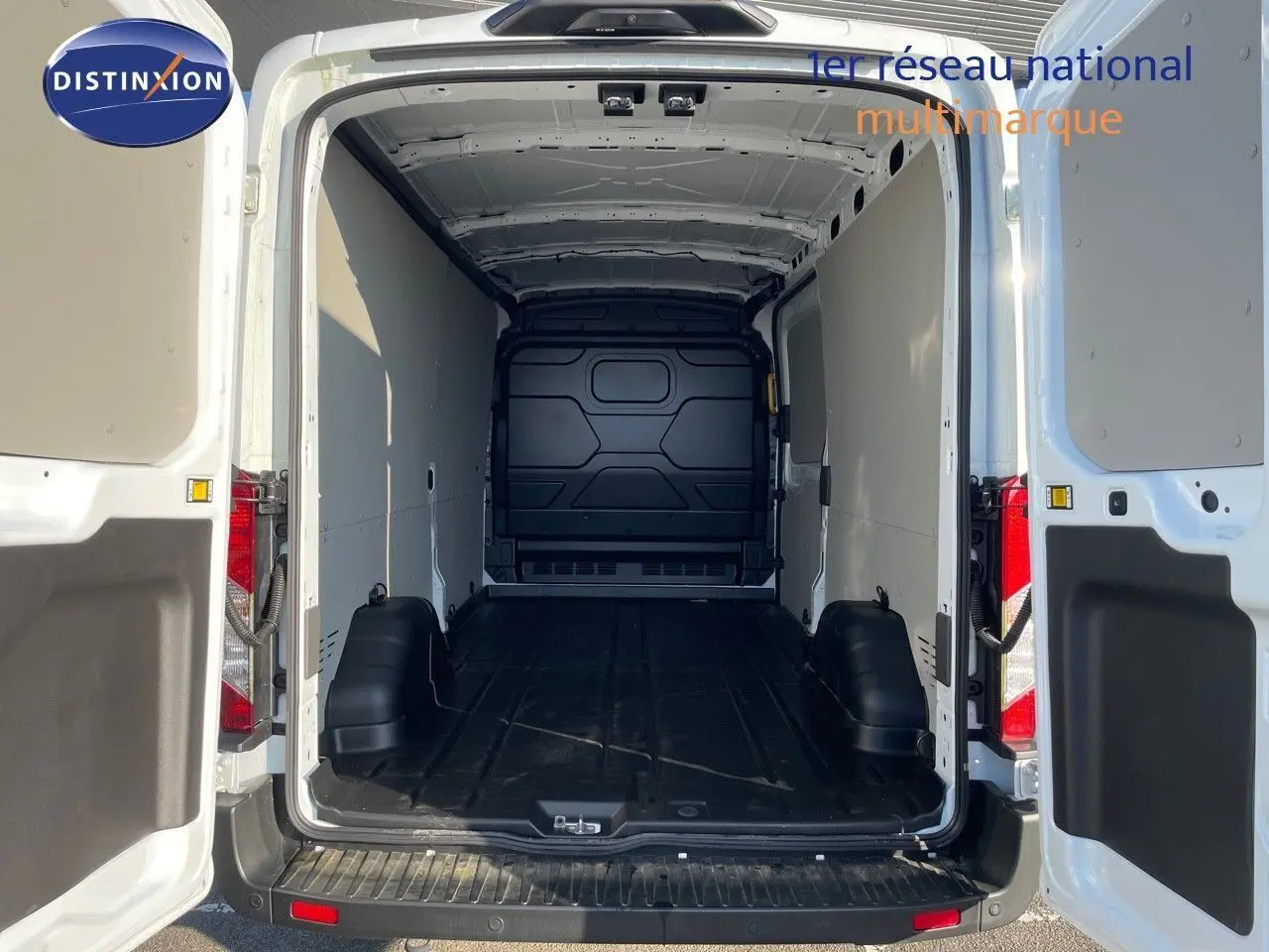 Vue arrière ouverte du Ford Transit Fourgon blanc 2023 montrant l'espace de chargement vide et les portes battantes ouvertes.