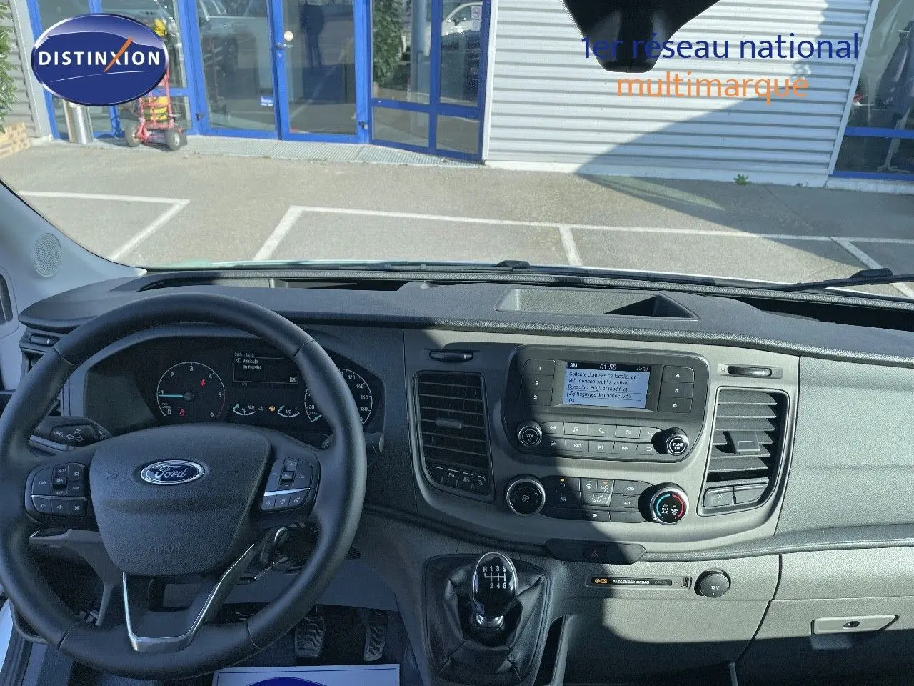 Vue intérieure du tableau de bord et volant du Ford Transit Fourgon blanc 2023 avec boîte manuelle et écran central.