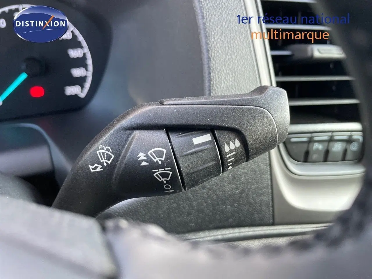 Gros plan sur la commande des essuie-glaces dans l'habitacle du Ford Transit Fourgon blanc 2023.