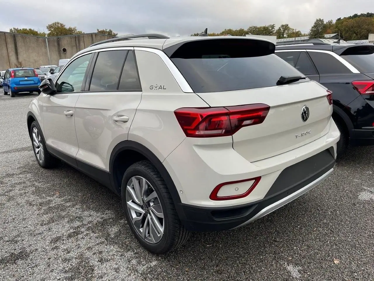 Vue 3/4 arrière droite d'un Volkswagen T-Roc gris Ascot 2025 avec feux LED et jantes alliage biton.