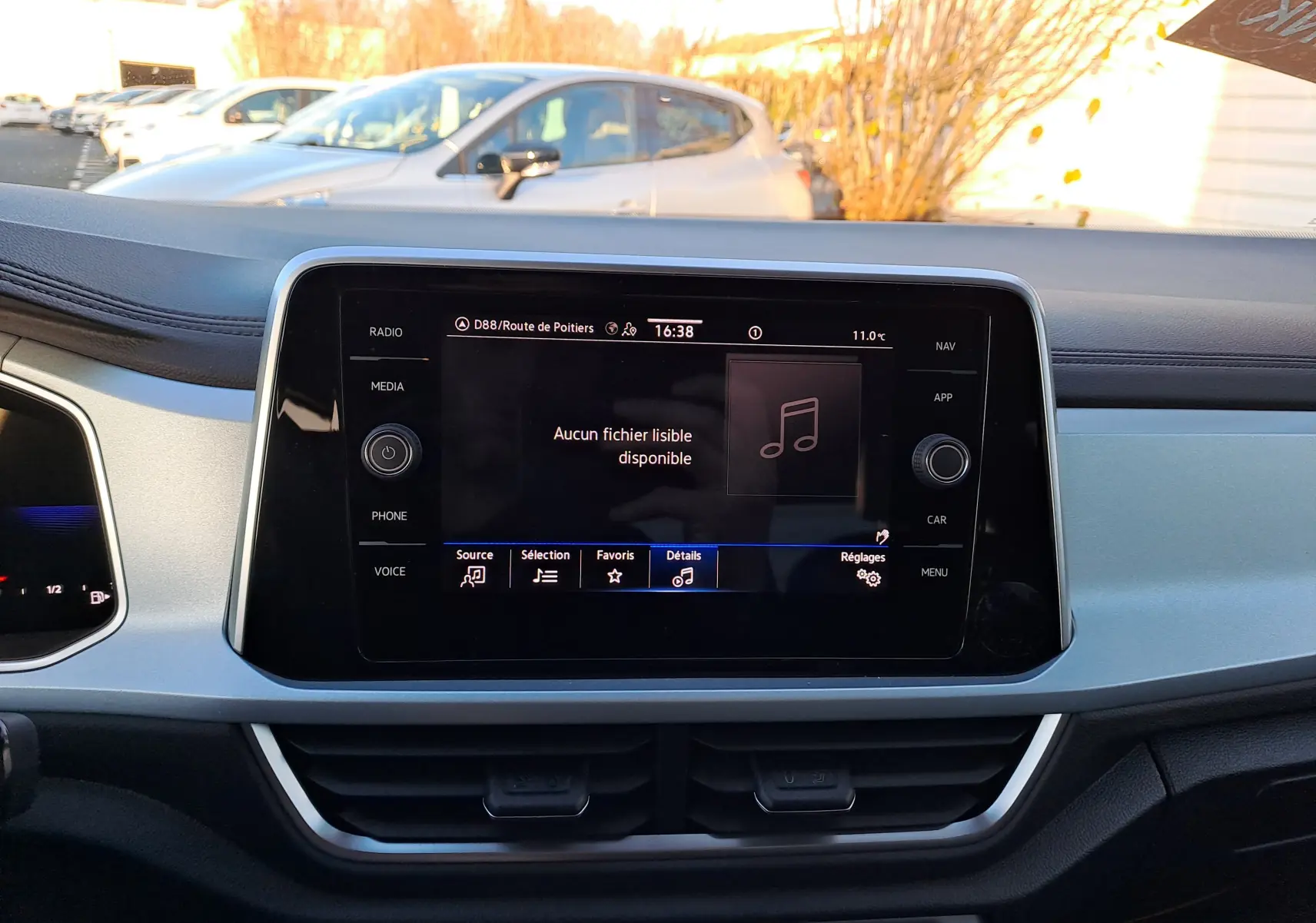 Vue intérieure centrée sur l'écran tactile multimédia du Volkswagen T-Roc gris Ascot, affichant le menu audio.