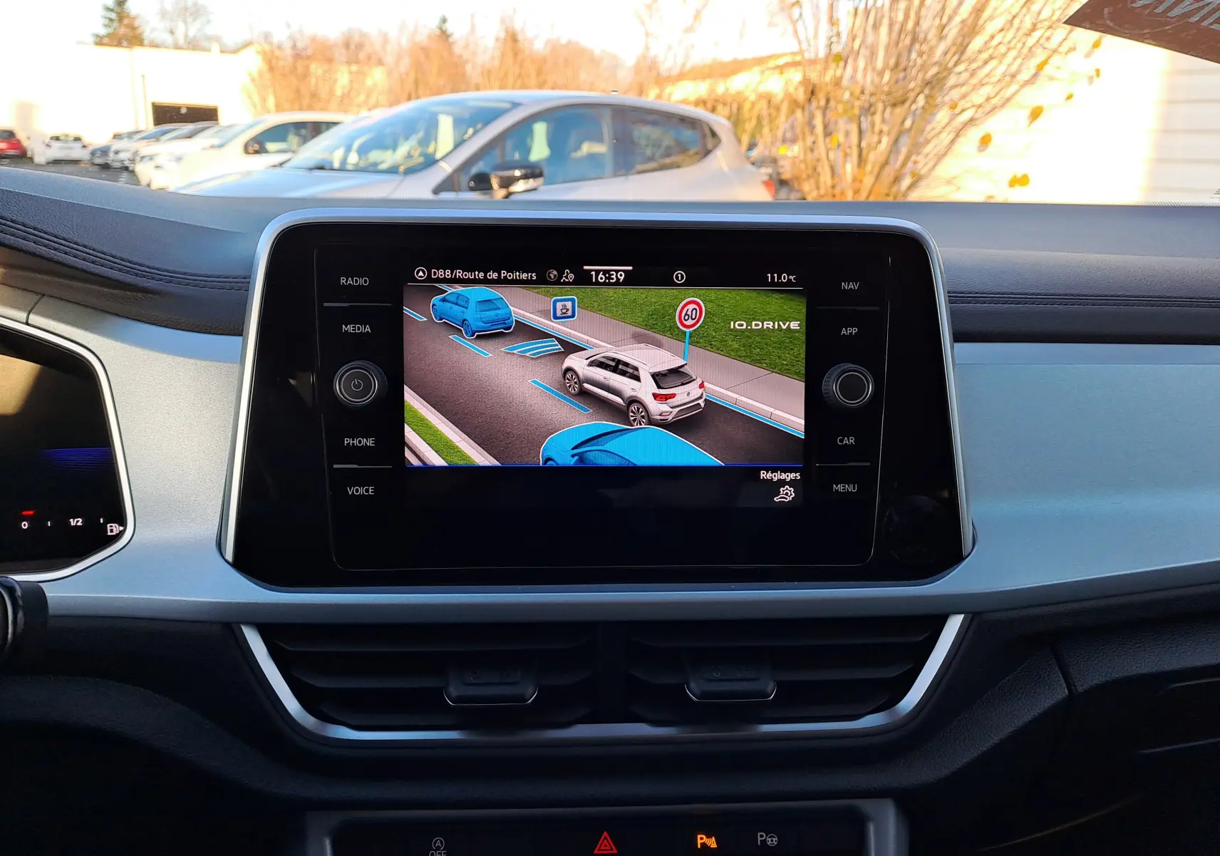 Vue intérieure du tableau de bord du Volkswagen T-Roc 2025 avec écran central affichant l'assistance à la conduite en gris Ascot.