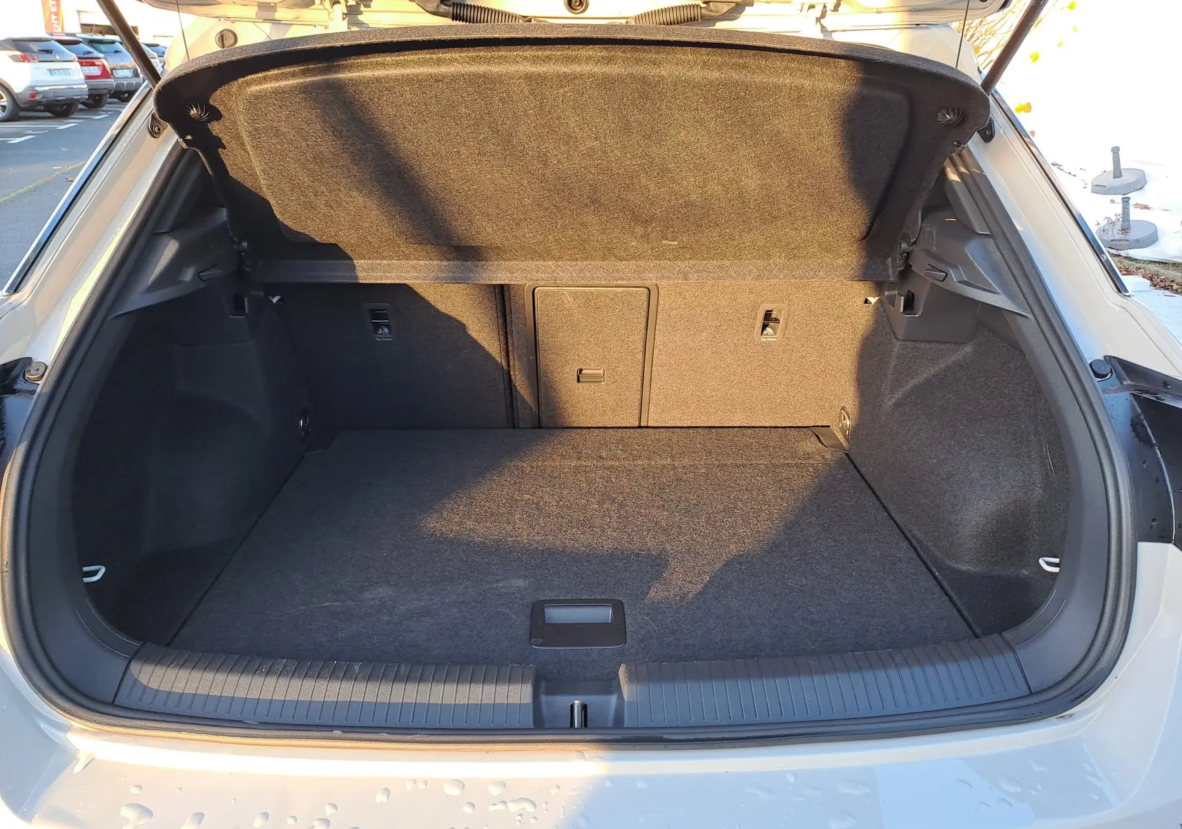 Coffre ouvert vu de l'arrière du Volkswagen T-Roc gris Ascot 2025, montrant un espace de chargement propre et spacieux.
