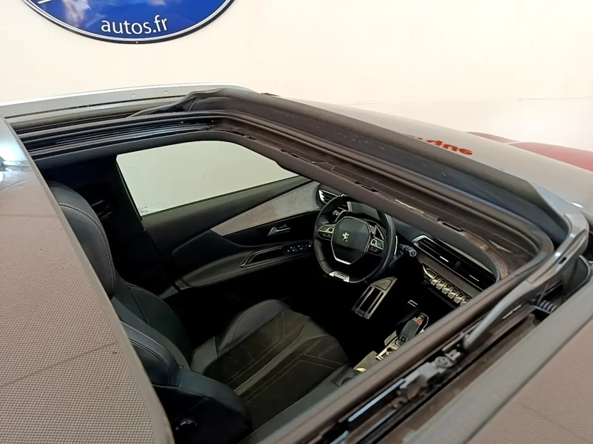Vue plongeante sur l'intérieur noir du Peugeot 3008 GT 2021, avec volant cuir et tableau de bord moderne visible.