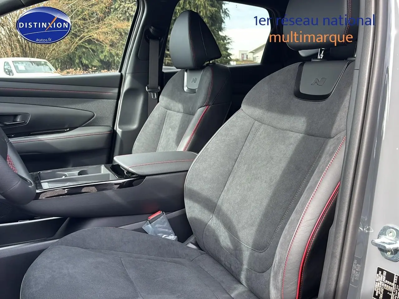 Vue intérieure côté droit sur les sièges avant gris avec surpiqûres rouges et logo N du Hyundai Tucson 2026.