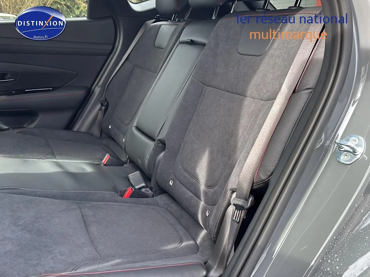 Vue intérieure côté droit des sièges arrière en tissu gris avec surpiqûres rouges du Hyundai Tucson 2026 Gris Shadow.