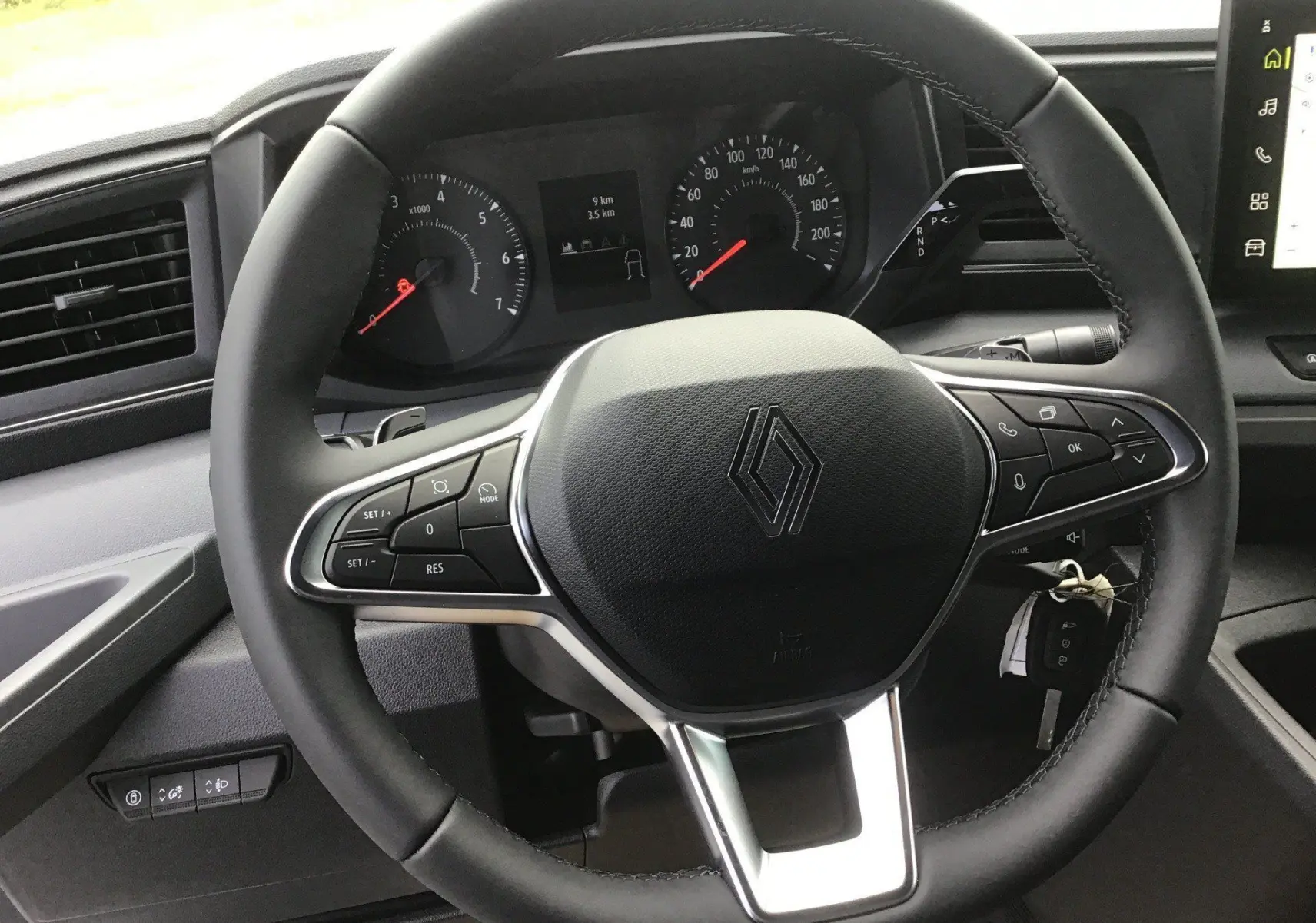Vue rapprochée du volant noir du Renault Master 2026 avec commandes intégrées et tableau de bord numérique.