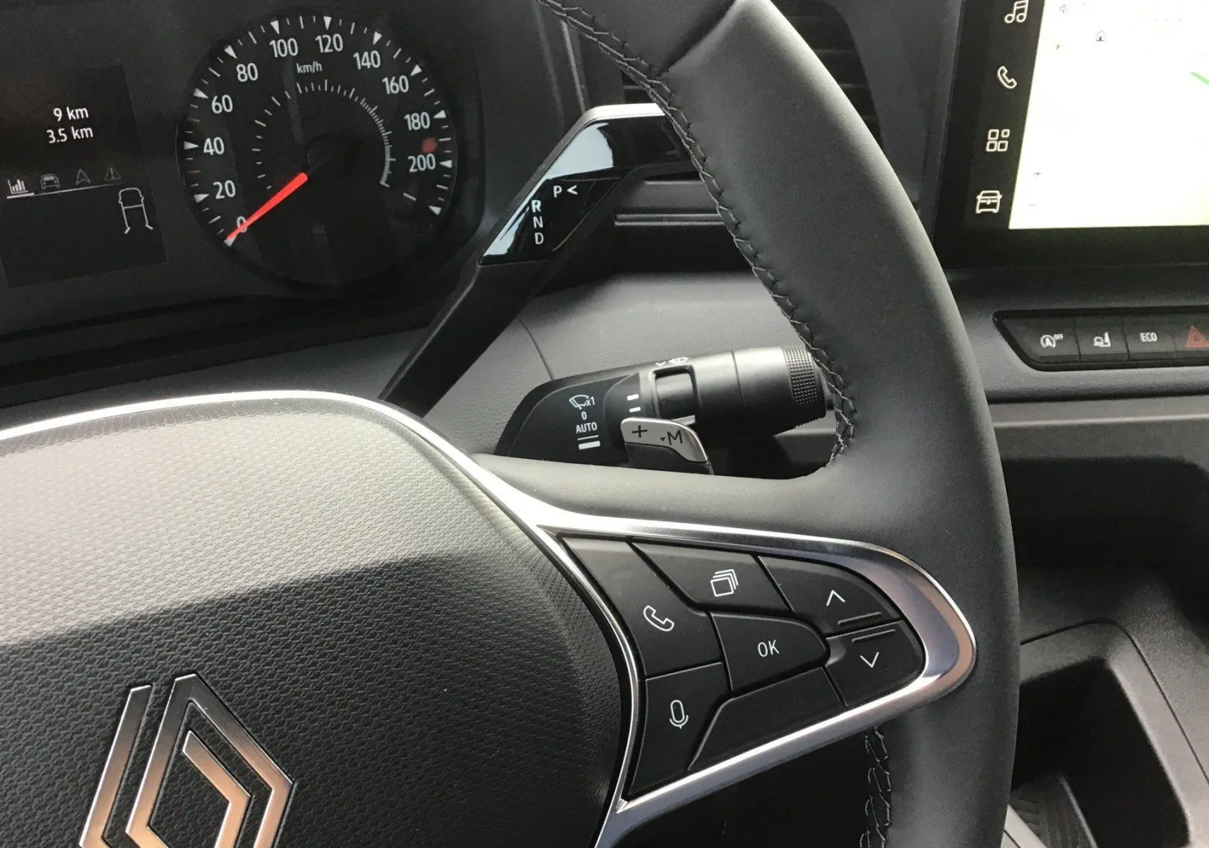Vue rapprochée du volant noir du Renault Master 2026, avec commandes intégrées et tableau de bord digital en arrière-plan.