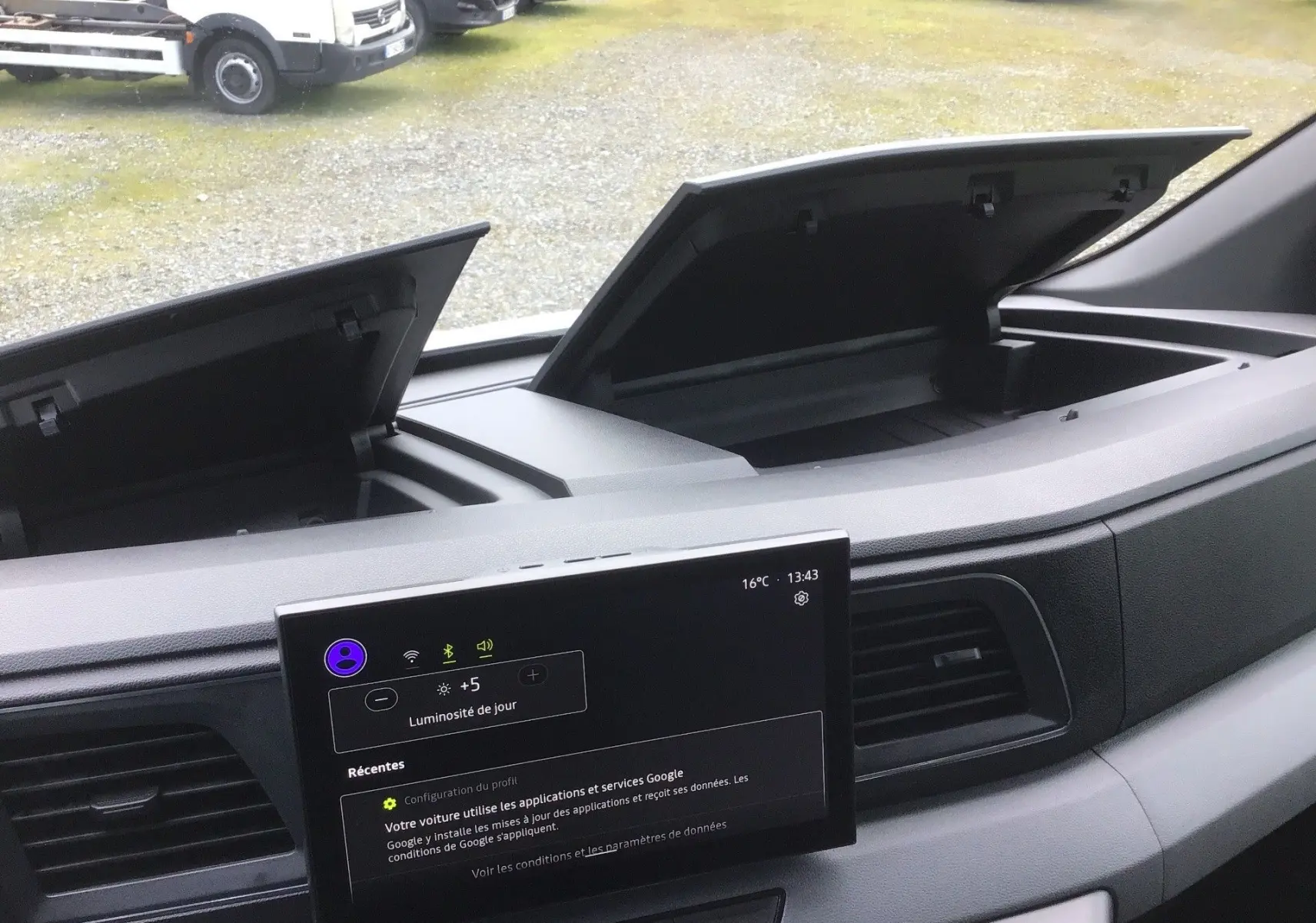 Vue intérieure du tableau de bord du Renault Master blanc 2026, avec deux compartiments de rangement ouverts et écran tactile central allumé.