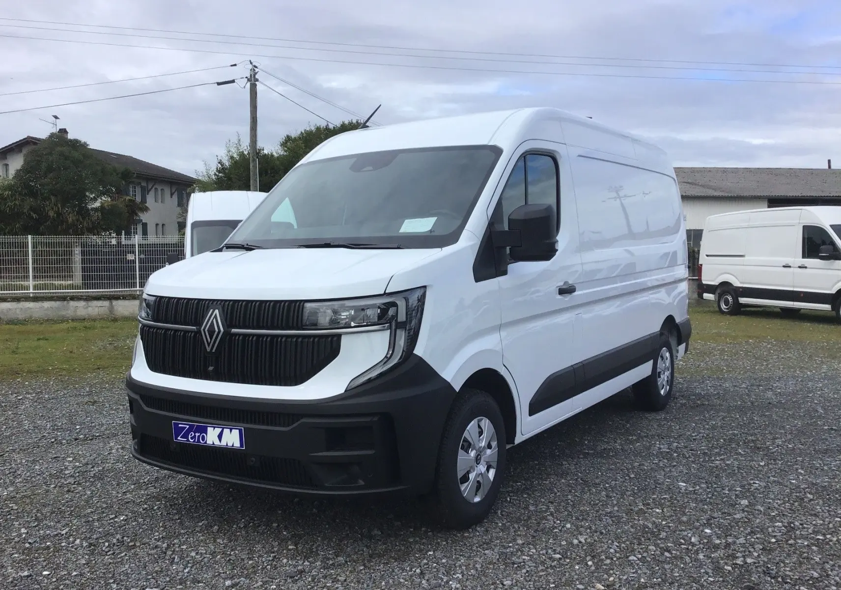 Renault Master blanc en vue 3/4 avant droit, avec calandre noire distinctive et pare-chocs noir mat.