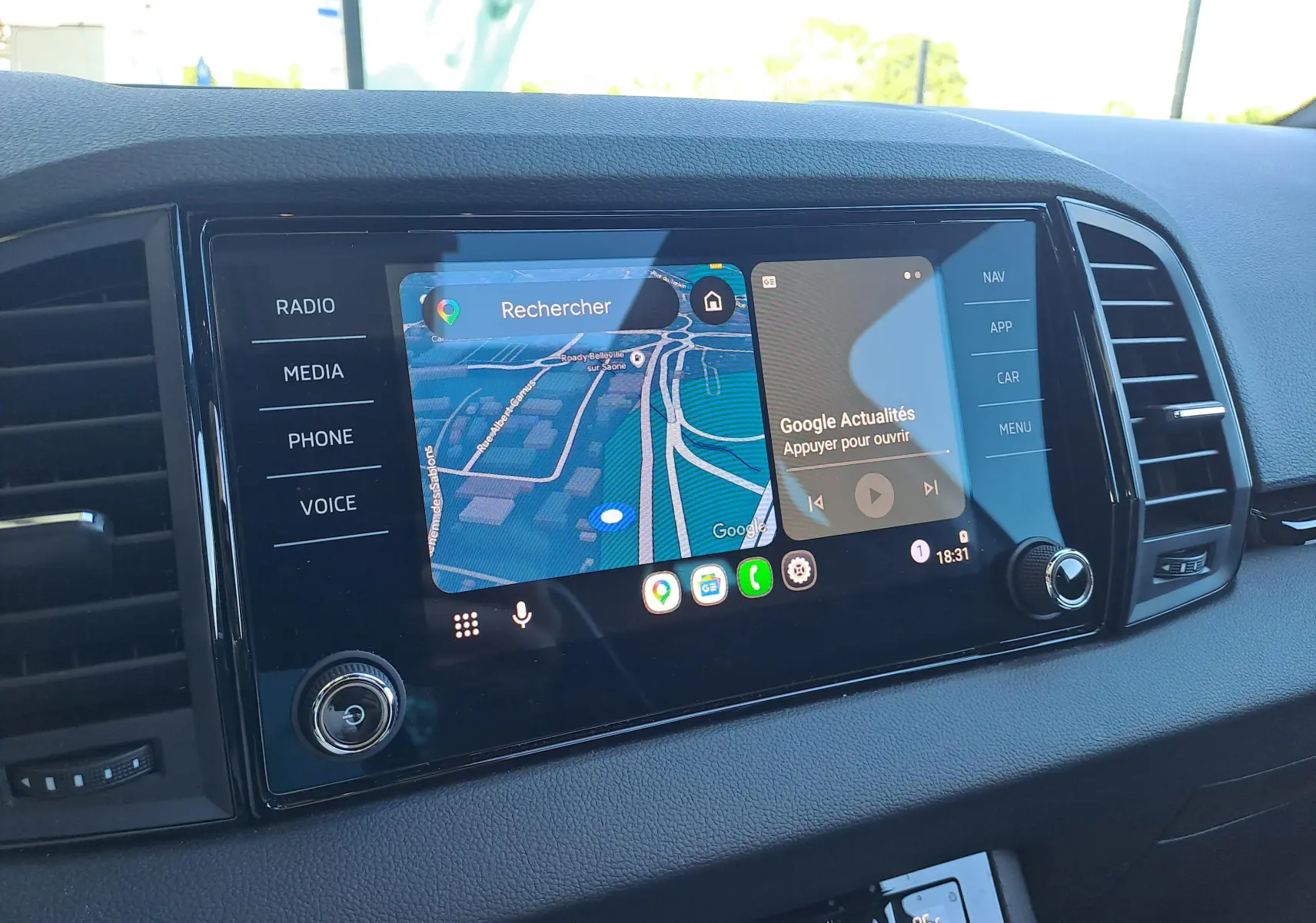 Écran tactile central du Skoda Karoq 2025 blanc lune, affichant navigation et applications, vue de face intérieure.