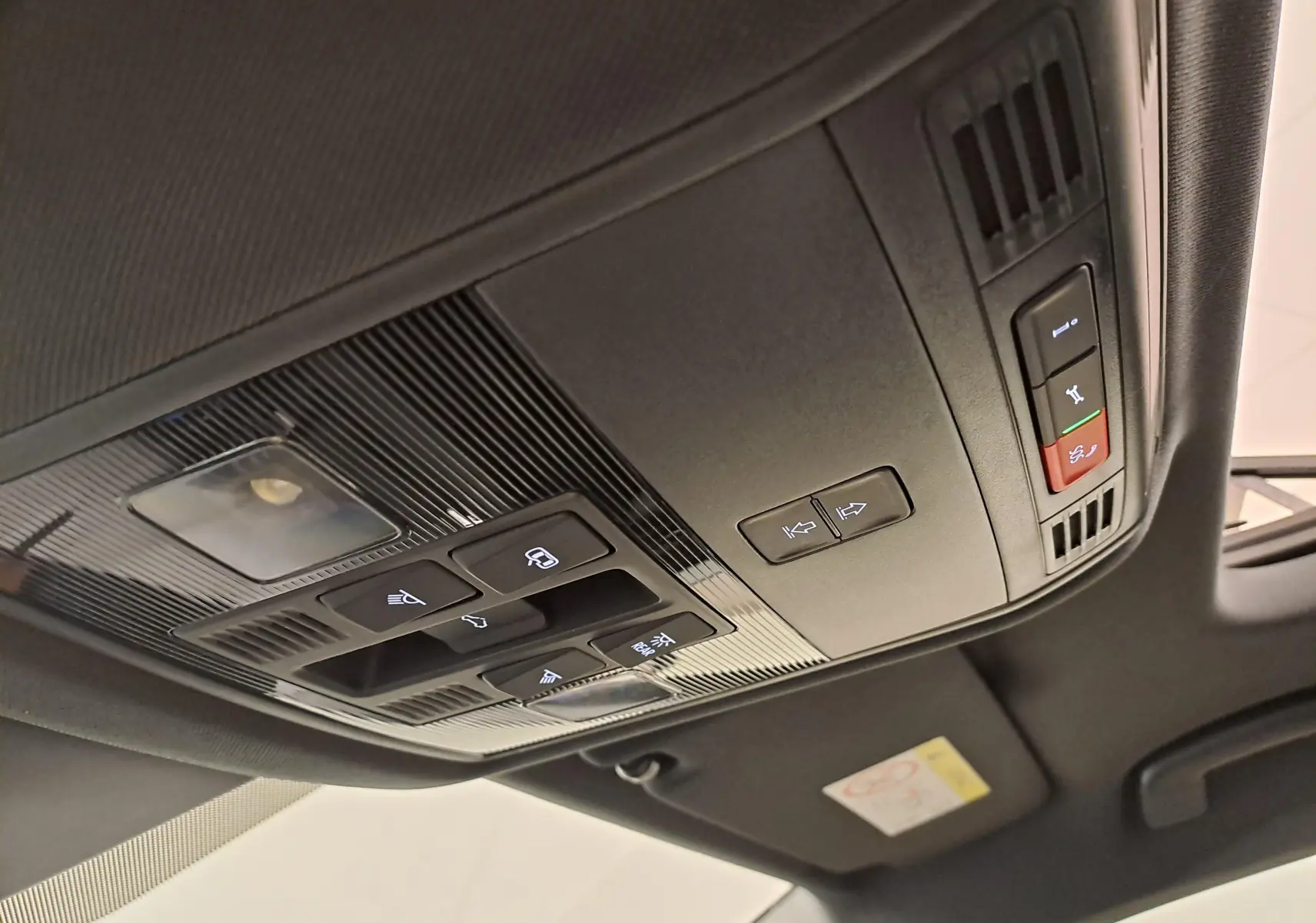 Plafonnier noir avec commandes d’éclairage et toit ouvrant partiel dans un Skoda Karoq Blanc Lune 2025 Sportline.