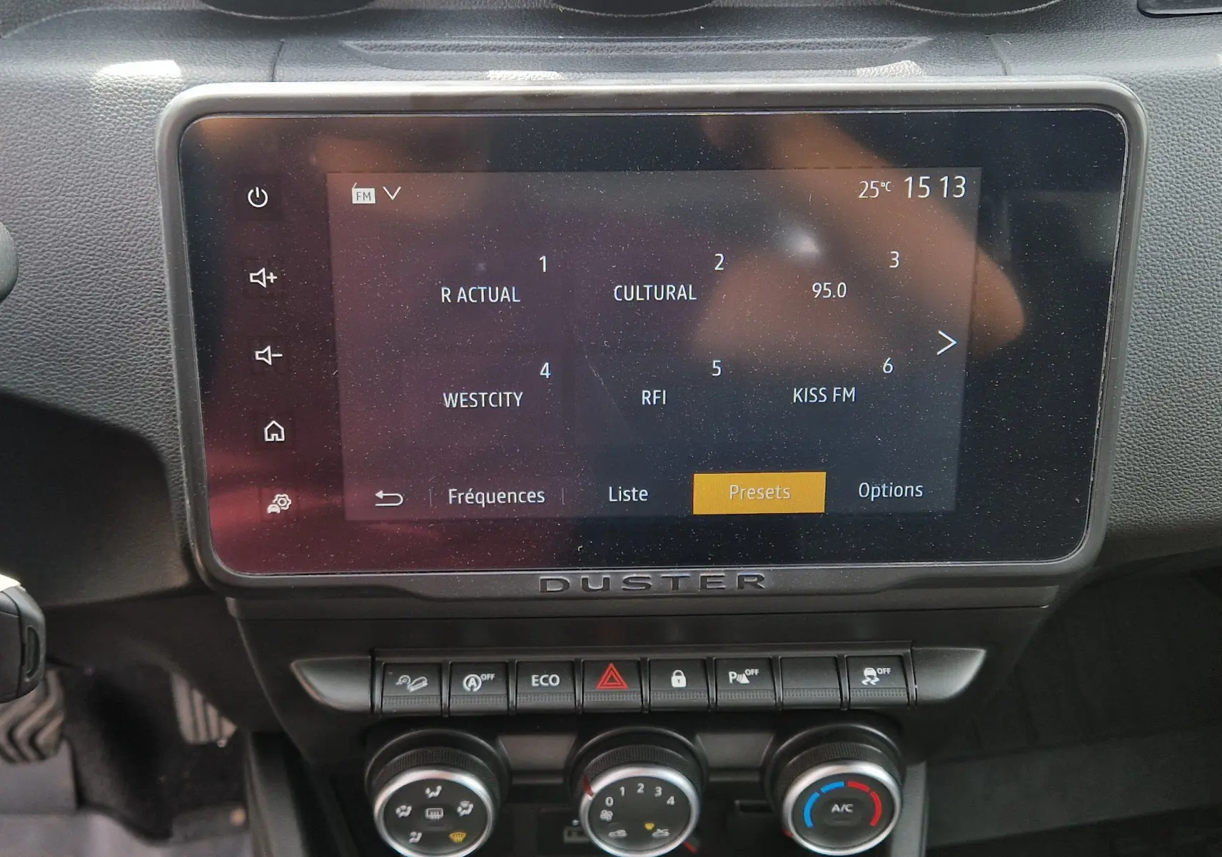 Écran tactile central du tableau de bord du Dacia Duster 2023 avec commandes climatisation et boutons fonctionnels.