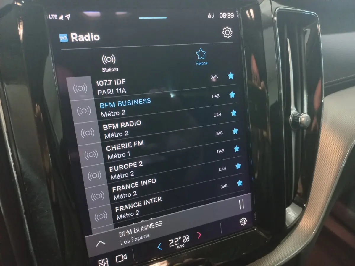 Écran tactile central affichant les stations radio dans l'habitacle d'un Volvo XC60 gris clair de 2022.
