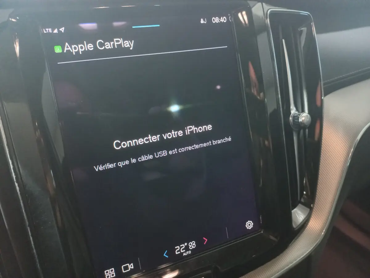 Écran tactile central du tableau de bord du Volvo XC60 gris clair, affichant la connexion Apple CarPlay.