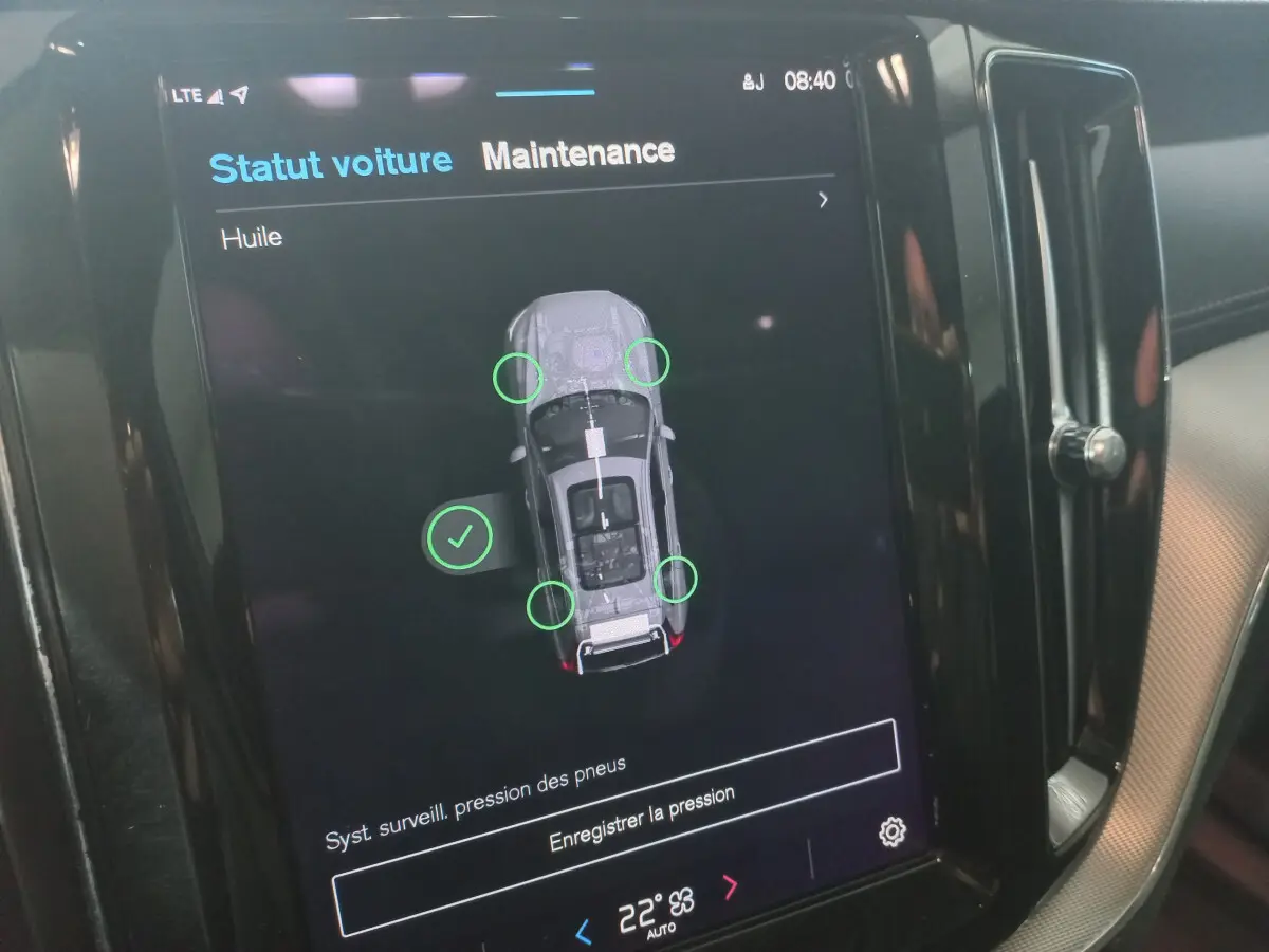Écran tactile intérieur affichant le statut maintenance du Volvo XC60 B4 gris clair, vue rapprochée du tableau de bord.