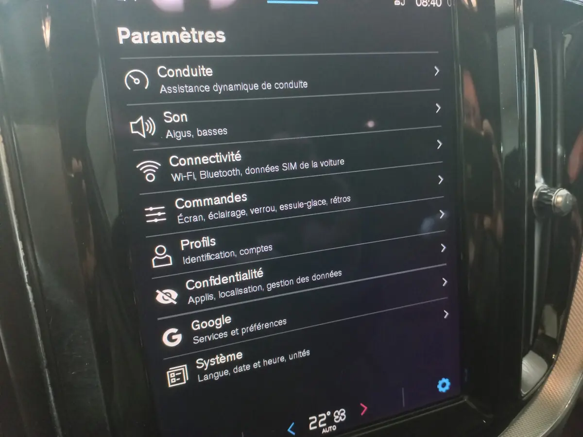 Écran tactile central du Volvo XC60 B4 gris clair, affichant les paramètres de conduite et connectivité.