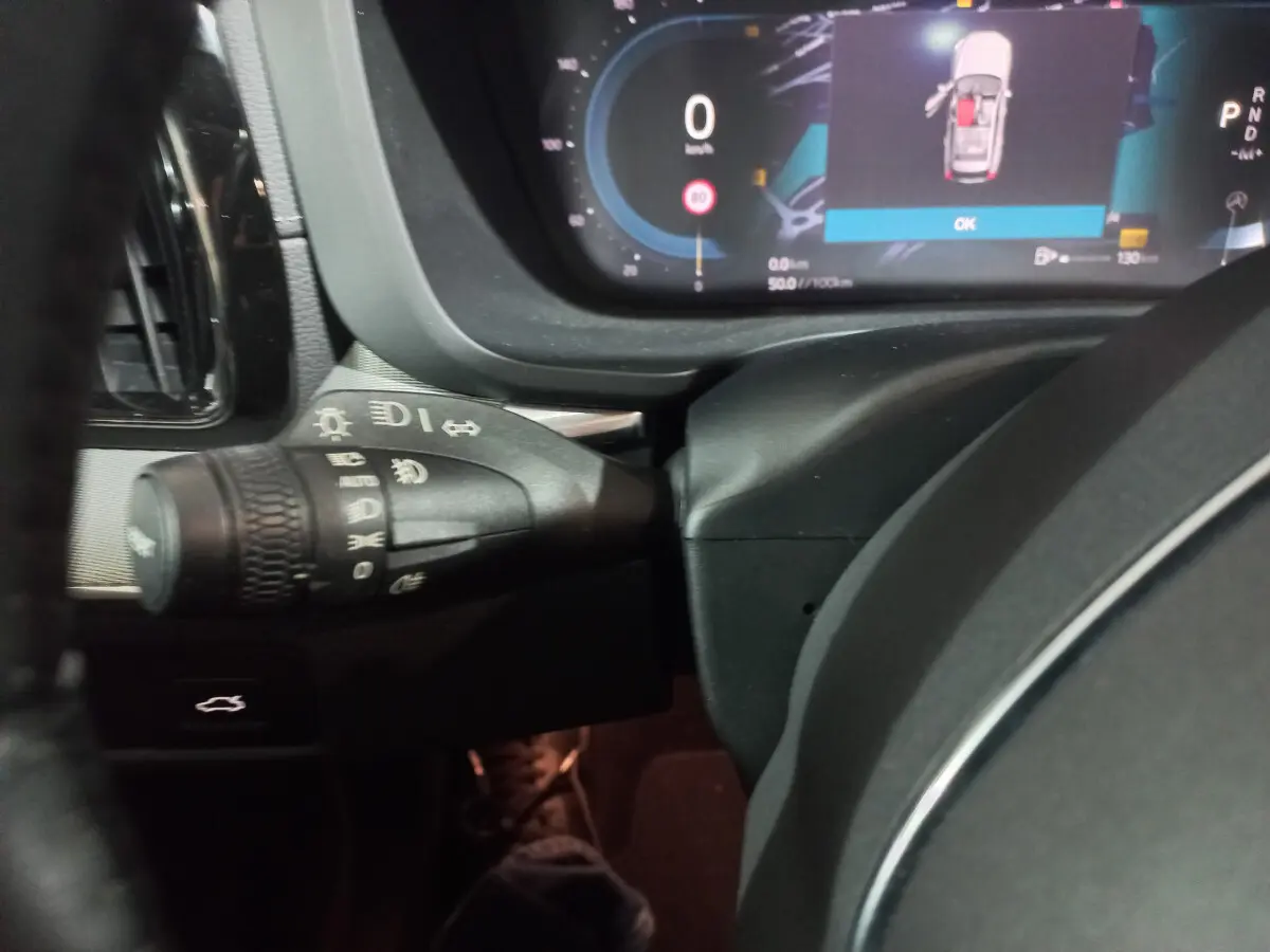 Gros plan sur la commande des phares et le tableau de bord numérique du Volvo XC60 gris clair, version 2022.