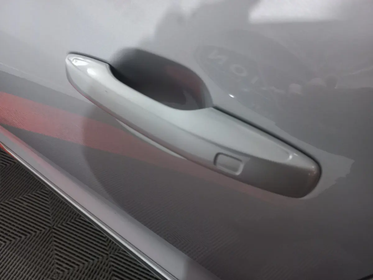 Poignée de porte gris clair en gros plan sur le côté droit d'un Volvo XC60 B4 2022 hybride essence.