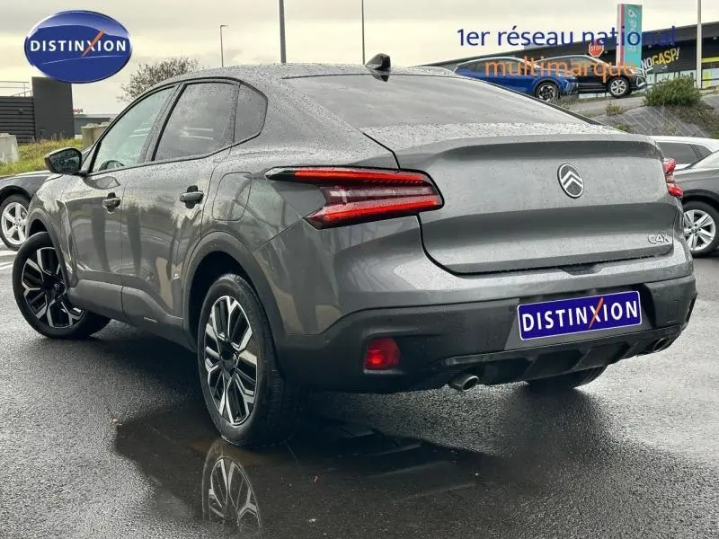 Vue 3/4 arrière droite d'une Citroën C4 X gris Mercury 2025 avec feux arrière LED et jantes alliage noires.