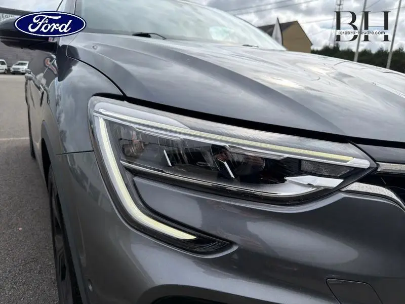 Gros plan sur le phare avant droit du Renault Arkana gris métallisé 2023, soulignant son design LED moderne.