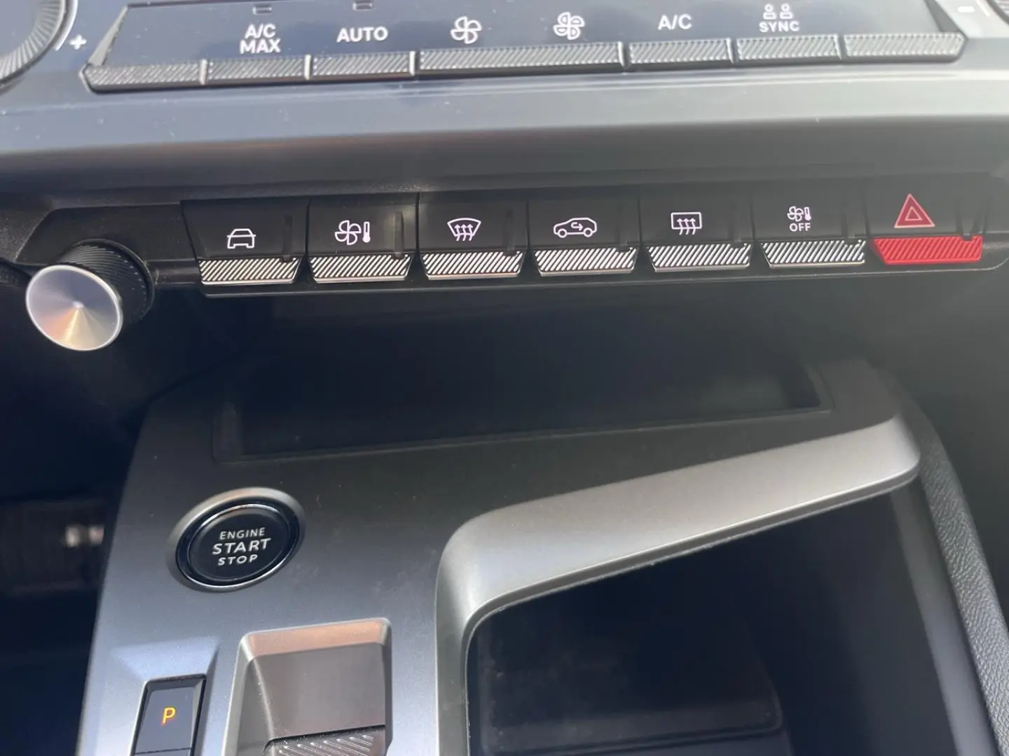 Vue rapprochée de la console centrale de la Peugeot 308 2024 avec boutons de commande et bouton start/stop.