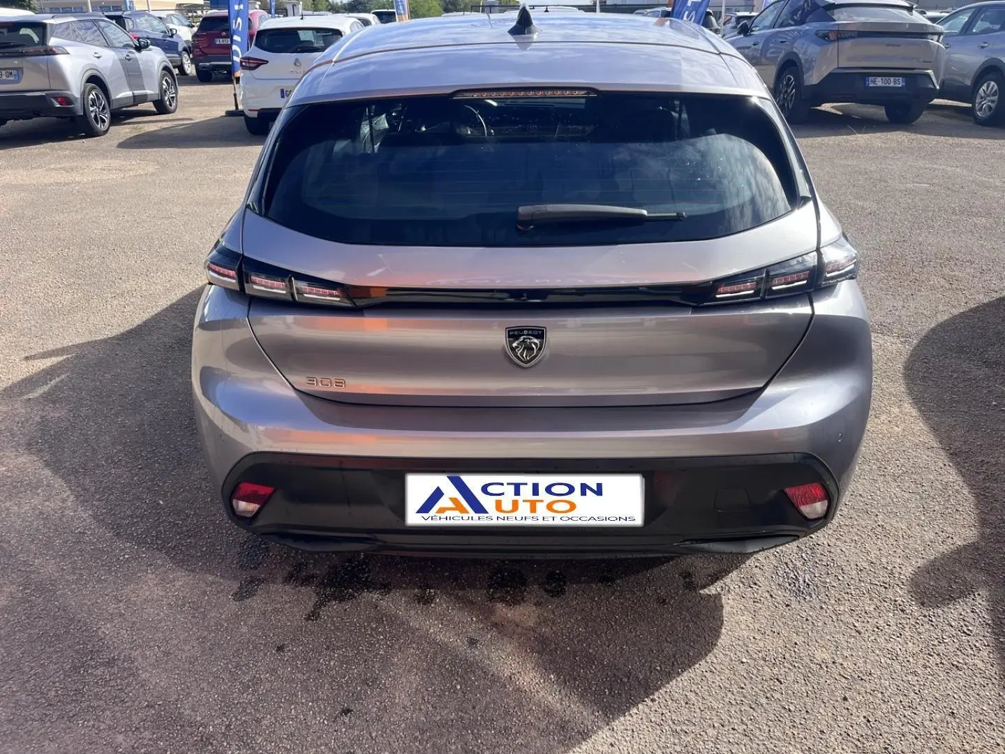 Vue arrière d'une Peugeot 308 gris Artense avec feux arrière LED et logo lion centré sur le hayon.