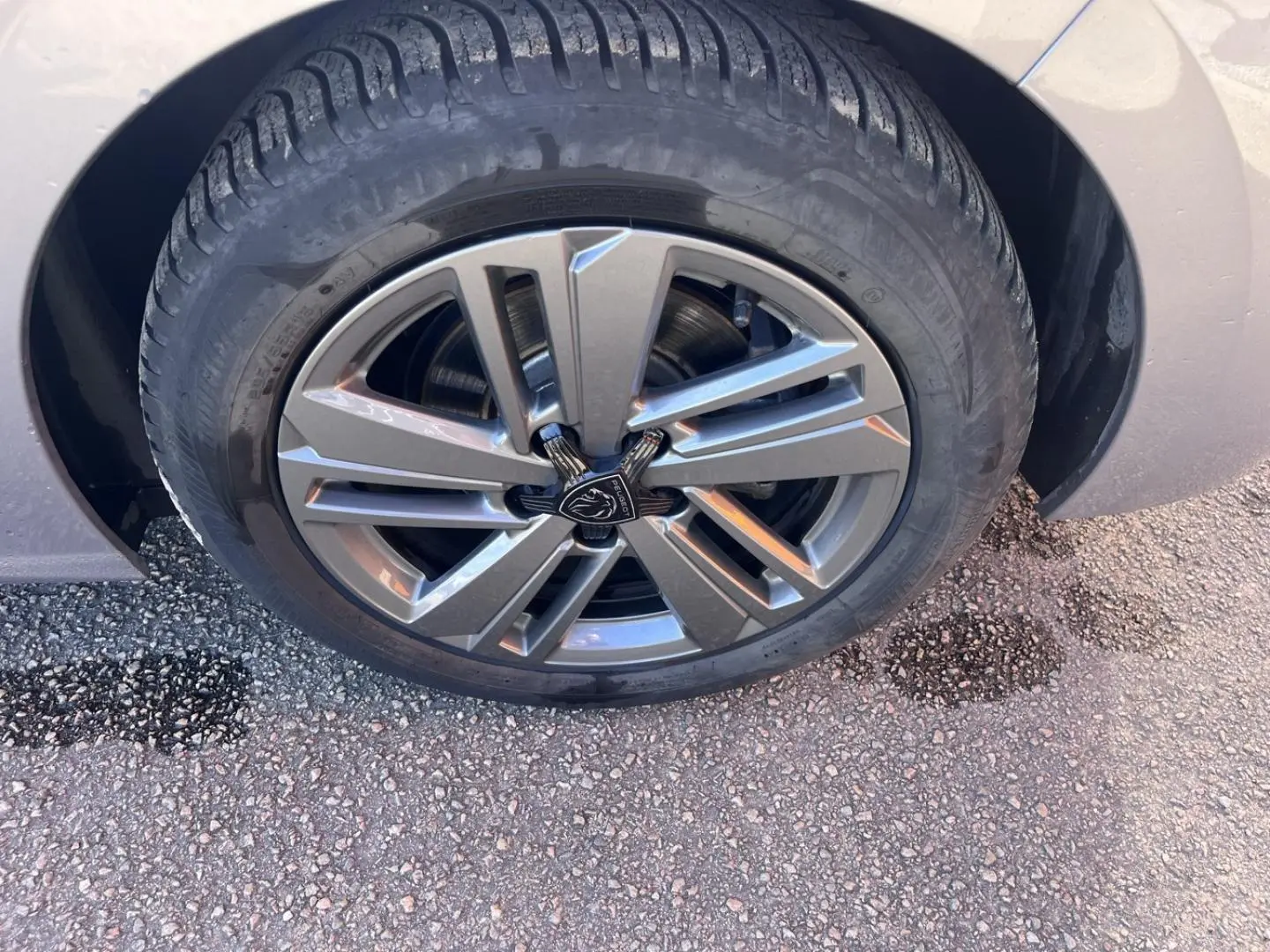 Gros plan sur la jante alu grise et le pneu d’une Peugeot 308 gris Artense, vue côté droit.